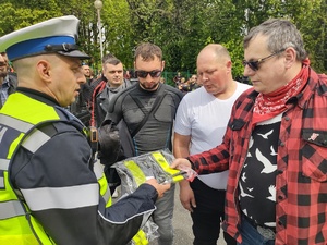 Policjant wręcza upominek jednemu z uczestników zjazdu