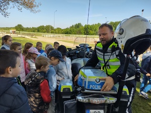 Policjant przy motocyklu rozmawia z dziećmi