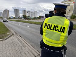 Policjant w trakcie pracy na ręcznym mierniku prędkości