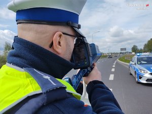 Policjant w trakcie pracy na ręcznym mierniku prędkośći