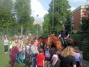 Dzieci zgromadzone licznie wśród policjantów na koniach