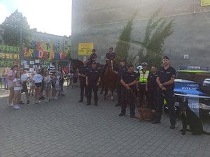 Policjanci i psy służbowe w towarzystwie dzieci pozują do zdjęcia