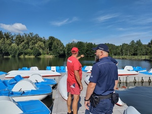 Ratownik pokazuje policjantom teren akwenu