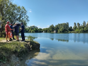 Policjant nad brzegiem zbiornika rozmawia z dziennikarzem