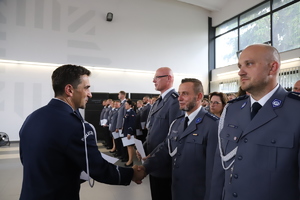 Komendant gratuluje jednemu z policjantów stojących w szeregu