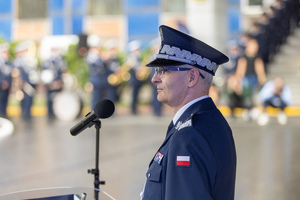 Policjant w umundurowaniu służbowym przemawia do mikrofonu