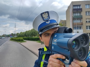 Policjantka mierzy prędkość miernikiem prędkości