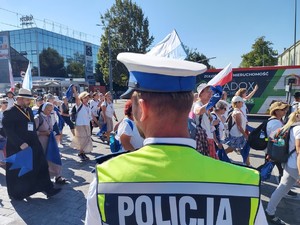 Policjant zabezpiecza przejście przez drogę pielgrzymów