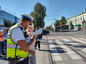 Policjant rozmawia z mężczyzna przed przejściem dla pieszych