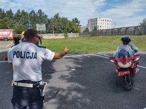 Policjant wskazuje ręka uczestnikowi na motocyklu