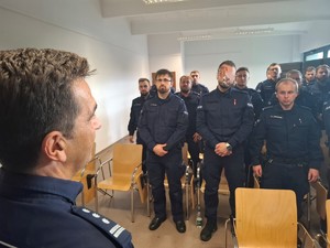 Komendant mówi do policjantów którzy stoją w sali