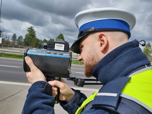 Policjant mierzy prędkość urządzeniem