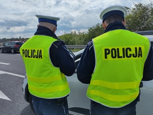 Policyjny patrol stoi przy drodze i kontroluje ruch pojazdów