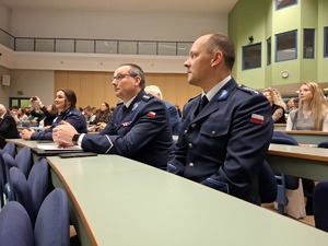 Policjanci siedzą w rzędzie podczas konferencji