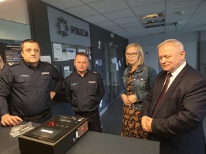 Wspólne pamiątkowe zdjęcie na tle ściany z napisem Policja