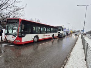 Uszkodzony autobus stoi na drodze, za nim stoją służby  służby