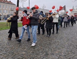 Młodzież idąc aleją, gra na instrumentach