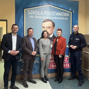 Policjant z grupa osób pozuje do zdjęcia