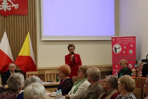 Kobieta przemawia do mikrofonu w sali konferencyjnej