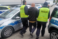 Policjanci doprowadzają zatrzymanego