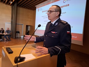 Komendant w mundurze galowym przemawia z mównicy