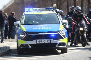 Policyjny radiowóz otoczony motocyklistami