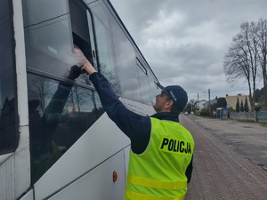 Policjant wykonuje badanie stanu trzeźwości kierującego autobusem