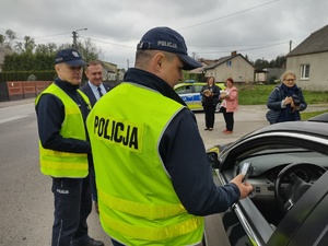 Policjanci i wójt rozmawiają z kierującym, którego zatrzymali do kontroli