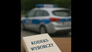 Napis Kodeks Wyborczy na tle policyjnego radiowozu