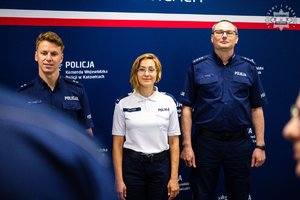 Policjantka pozuje do zdjęcia z dwoma policjantami