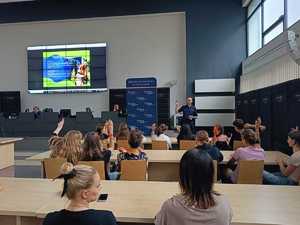 Dzieci siedzą w auli komendy w wyznaczonych miejscach