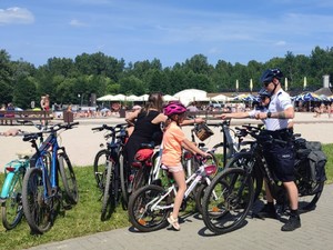 Policyjny rowerowy patrol rozmawia z małymi rowerzystami