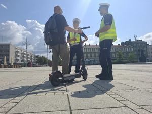 Policjanci rozmawiają mężczyzną na hulajnodze
