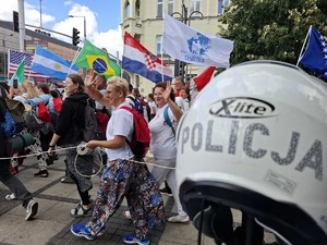 Policyjny kask na tle pielgrzymów