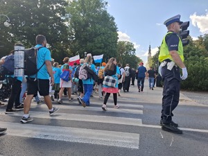 Policjant stoi na drodze podczas przemarszu pielgrzymów