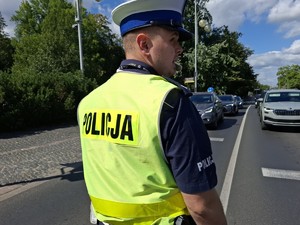 Policjant stoi na drodze, przed nim oczekują pojazdy