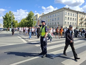 Policjant zabezpiecza przejście po którym idą piellgrzymi