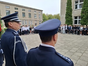 Policjanci stoją na placu wśród uczniów podczas obchodzonych uroczystości