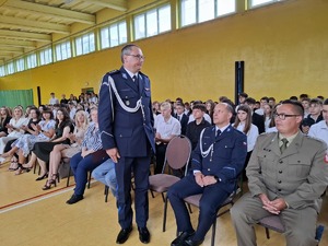 Komendant w umundurowaniu galowym podczas powitania  stoi wśród obecnych na uroczystości