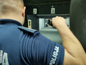 Policjant trzyma w ręce rozładowaną do przejrzenia broń
