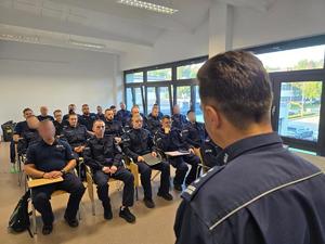 Komendant rozmawia z uczestnikami kursu w sali wykładowej