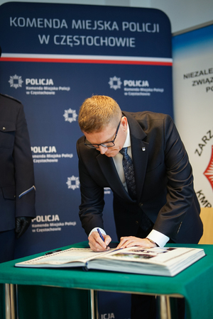 Mężczyzna dokonuje wpisu do książki