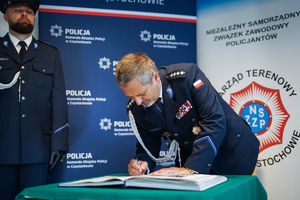 Policjant dokonuje wpisu do książki