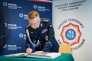 Policjant dokonuje wpisu do książki