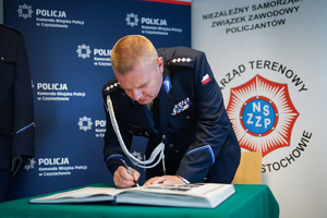 Policjant dokonuje wpisu do książki