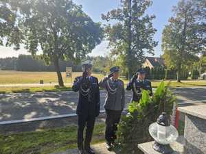 Policjanci oddają honor przed pomnikiem