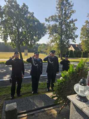 Policjanci oddają honor przed pomnikiem