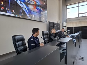 Komendant w mundurze rozmawia z sędziami przy mównicy