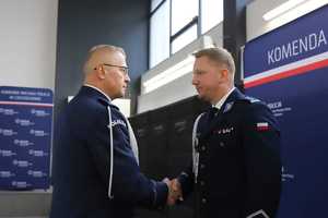 Dwóch policjantów podają sobie prawe dłonie