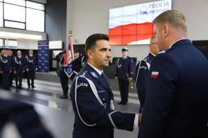 Policjanci podają sobie prawe dłonie